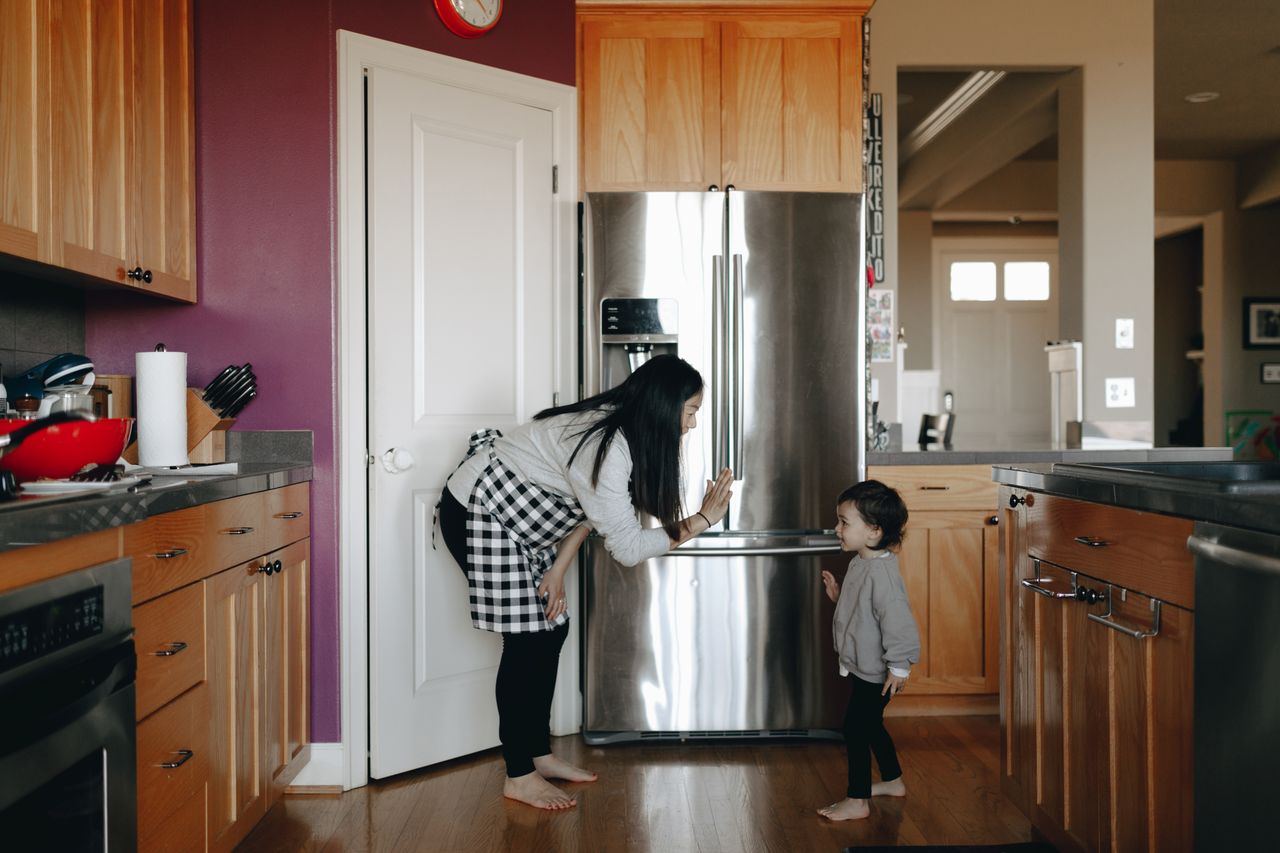 our-mission A mother interacting with her child in a cozy, modern kitchen setting.